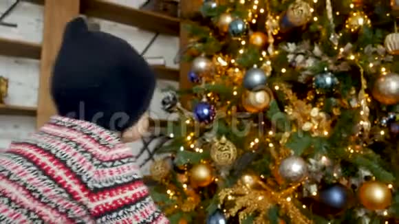 婴儿爬到圣诞树上坐着视频的预览图
