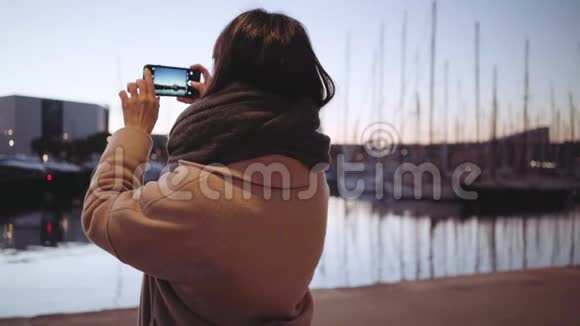 女游客拍摄日落时的游艇照片视频的预览图