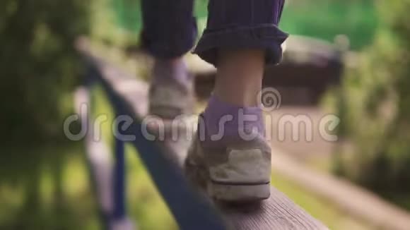 儿童腿部特写孩子在横梁上在空中保持平衡幸福安详的概念视频的预览图