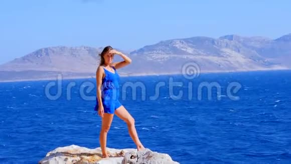 美丽的女人穿着蓝色的整体服装靠近大海视频的预览图