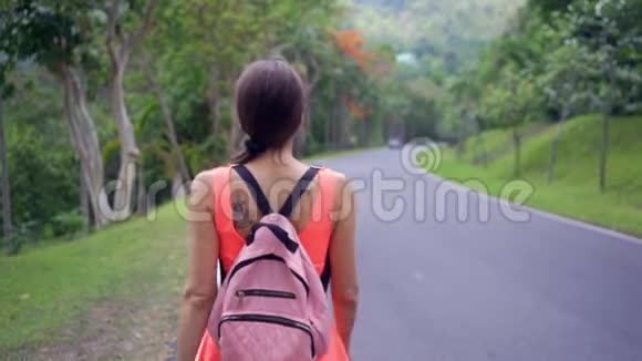 美丽的雨林与一位年轻的女旅行者在进入泰国森林的道路上女人在雨林里散步视频的预览图