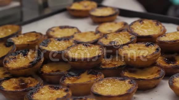 传统的葡萄牙鸡蛋手拿馅饼馅饼蛋糕甜点巴迪斯德纳塔与不同的葡萄牙糕点视频的预览图