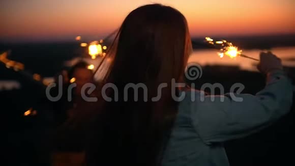 快乐的女性朋友在日落时分在山上玩星星之火视频的预览图