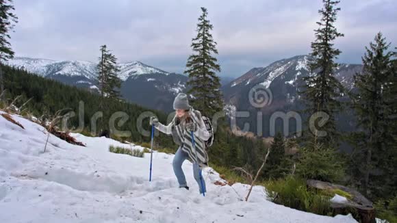 决心坚定的年轻女子在冬天带着雪爬山慢动作视频的预览图