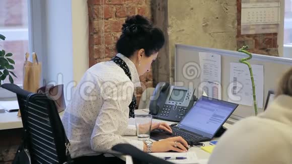 年轻女经理在她的笔记本电脑上通过电子邮件咨询客户的画像视频的预览图