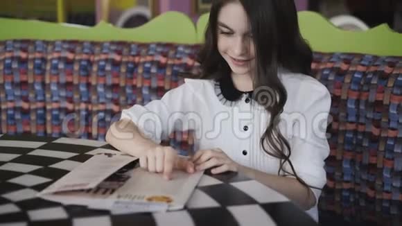 漂亮的女孩在看菜单并下订单4K视频的预览图