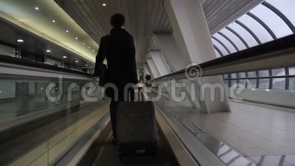 这名韩国男子站在现代机场的大走廊上的旅行家视频的预览图