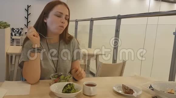 年轻漂亮的女人红头发坐在餐馆里吃素食健康的生活方式视频的预览图