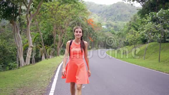 美丽的热带雨林带着一位年轻的女旅行者在进入泰国森林的路上女人在雨林里散步视频的预览图