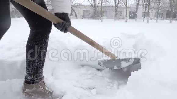 冬天的工作人们用铁锹在下雪的时候打扫庭院视频的预览图