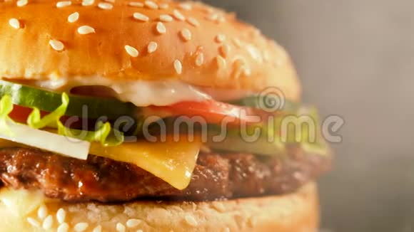 含切片洋葱蔬菜融化奶酪生菜酱汁和芝麻的果汁牛肉汉堡孤立视频的预览图