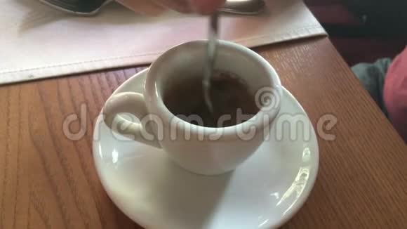 我们在咖啡馆的小杯子里搅拌一勺咖啡视频的预览图