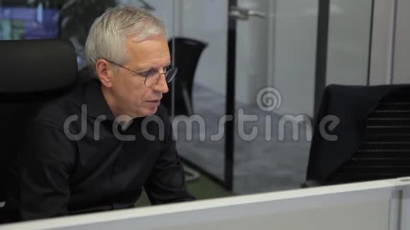 高级主管在现代办公室坐在电脑前工作视频的预览图