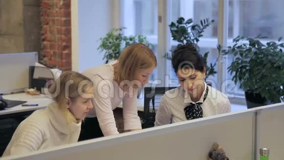 三位年轻的女设计师正在现代办公室讨论这个项目视频的预览图