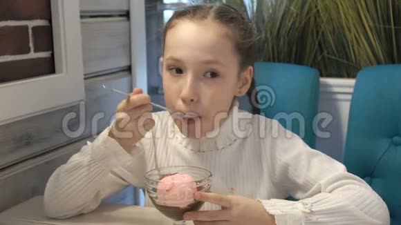 一个小女孩坐在咖啡馆里吃巧克力冰淇淋特写高细节视频的预览图
