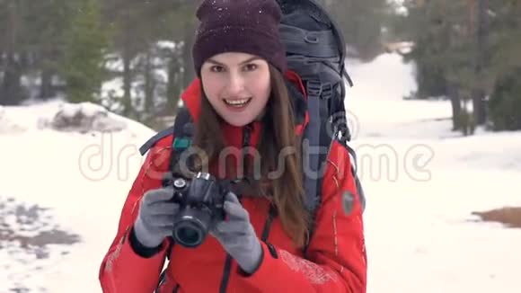 快乐的游客带着照片相机在森林里边下雪边拍照视频的预览图