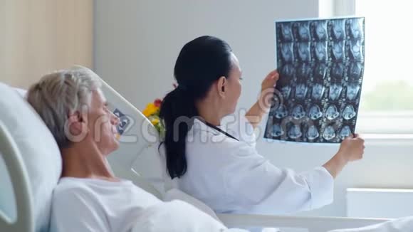 年轻的女医生给她的老年病人做了X光扫描视频的预览图