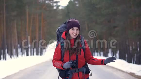 快乐的游客开始了她的旅行在阳光明媚的冬季森林里沿着道路奔跑高清视频的预览图