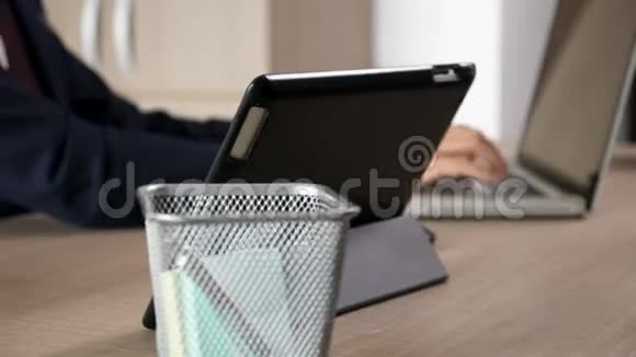 商人手在电脑上打字然后在平板电脑上多任务处理视频的预览图