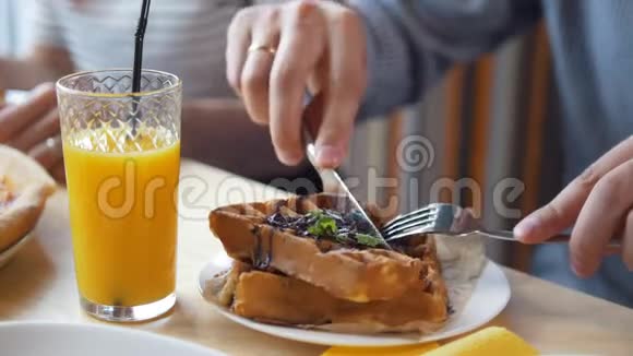 男性手用餐刀和叉子切美味的比利时华夫饼视频的预览图