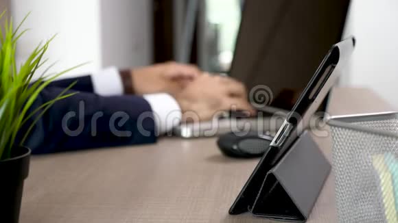 在他的办公室里用平板电脑把商人的双手合上视频的预览图