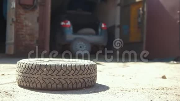 在车库前的地面上滚动轮胎视频的预览图