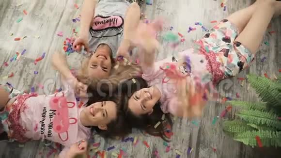 三个十几岁的女朋友躺在地板上的俯视图十几岁的时髦朋友吹吹风庆祝聚会视频的预览图