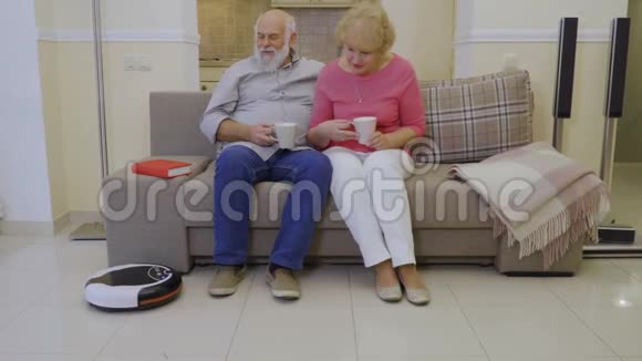 用吸尘器清洁客厅的地板时老人在沙发上放松视频的预览图