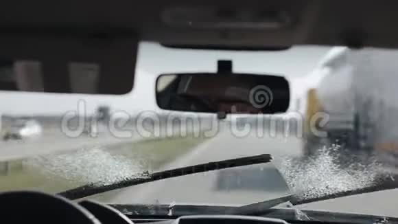 开着一辆有挡风玻璃雨刷的车清洁挡风玻璃司机后视镜反射视频的预览图