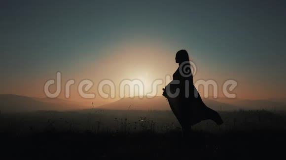 一位美丽的年轻女子在山上奔跑的剪影手里拿着一只帕雷奥慢动作的概念视频的预览图