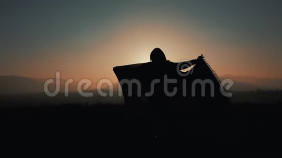 一位美丽的年轻女子在山上奔跑的剪影手里拿着一只帕雷奥慢动作的概念视频的预览图