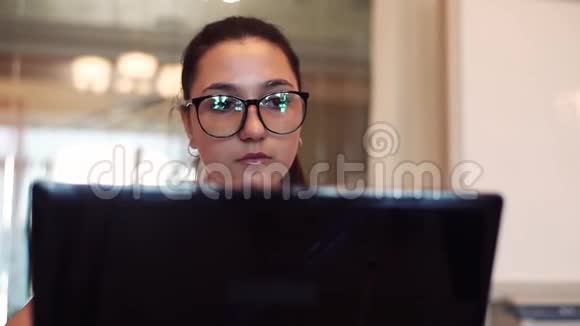戴眼镜的女商人在办公室里用电脑工作特写镜头视频的预览图