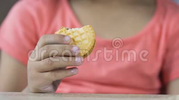 小女孩吃美味的饼干有食欲不健康的食物特写视频的预览图