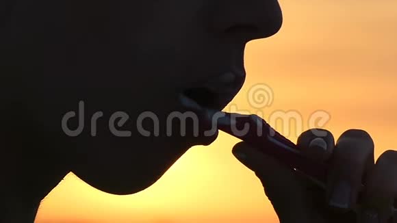 日落时分年轻女子用塑料刷子刷牙视频的预览图