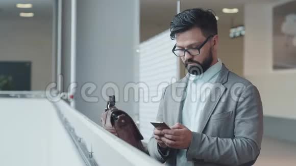 生意兴隆男人正侧身站着用智能手机拍照视频的预览图