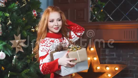漂亮的红发女孩穿着红色毛衣手里拿着圣诞礼物视频的预览图