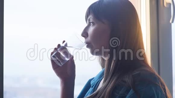 年轻女子喝着一杯水视频的预览图
