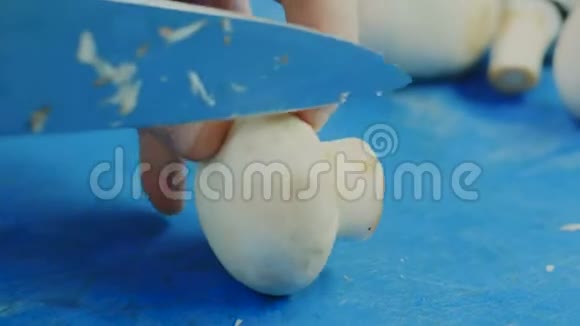 厨师切蘑菇一位女厨师的头上镜头在一块切碎的木板上切蘑菇视频的预览图