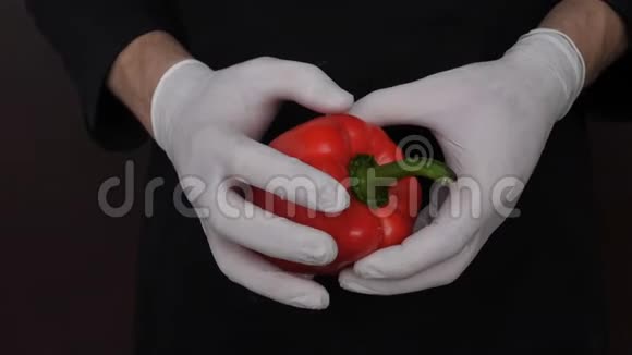男人手里拿着红辣椒被撕成两半黑色背景的视频视频的预览图