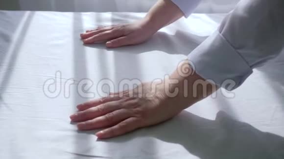 按摩师用白色布滑动女手按摩台上贴无菌床单视频的预览图