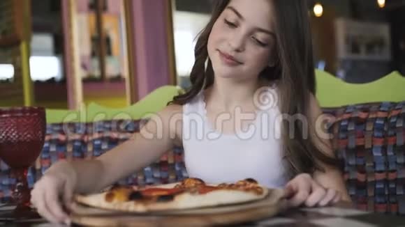 微笑的女孩在咖啡馆里旋转着欣赏着披萨的展示4K视频的预览图