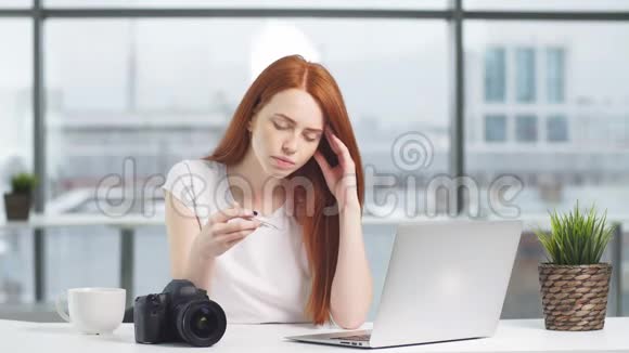 优雅的红发女孩在办公室工作感觉不舒服视频的预览图