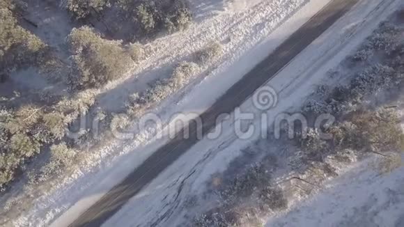 汽车在冬天的道路上行驶上面覆盖着白雪的树木视频的预览图