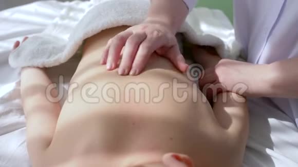 小儿推拿女医生的手正在给小男孩做背部按摩特写视频的预览图