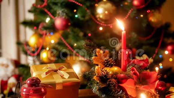 特写4k镜头的蜡烛和传统花环与发光的圣诞灯在夜间完美的背景视频的预览图