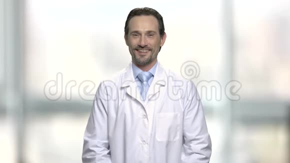 英俊的成熟医生显示OK标志视频的预览图