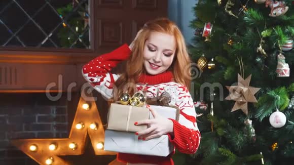 快乐的红发女孩拿着圣诞礼物微笑着视频的预览图