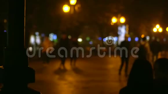 人们在傍晚的公园里散步晚上的城市傍晚的灯光闪闪发光视频的预览图