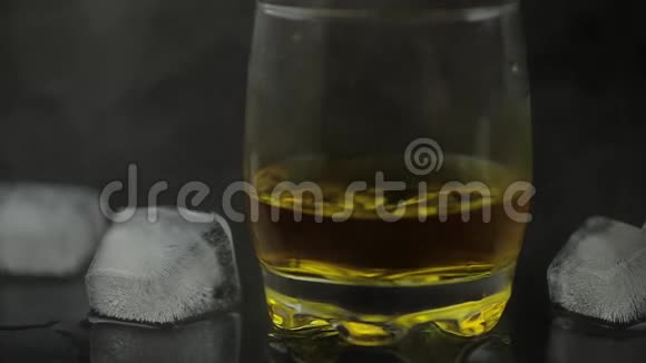 威士忌加冰在黑色背景上添加冰块一杯朗姆酒视频的预览图