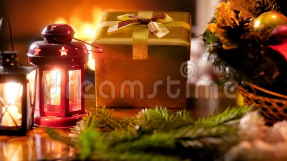 在燃烧的壁炉旁木桌上的传统圣诞装饰和礼物的特写镜头视频的预览图